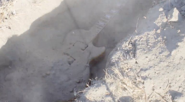 Guitar Max vergraebt Gitarre in der wüste